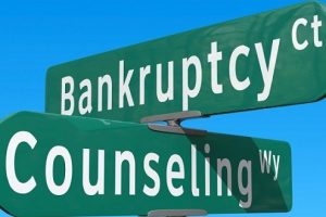 the words bankruptcy and counseling written on two green street traffic signs