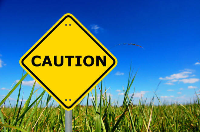 sign reading caution in a field of grass